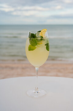 Lemon cocktail with mint on a table by the beach.