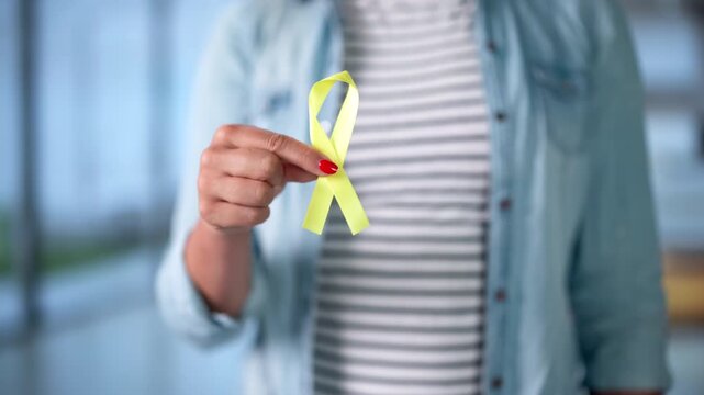 Young Woman Gently Holds A Yellow Ribbon Symbolizing