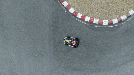 Fototapeta premium Aerial view go kart racer race curve circuit, Go kart at circuit curve, Top view race go kart track curve.