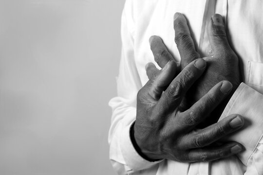 praying to god with hands showing his religious faith with God Caribbean man praying with background with people stock photo stock image	