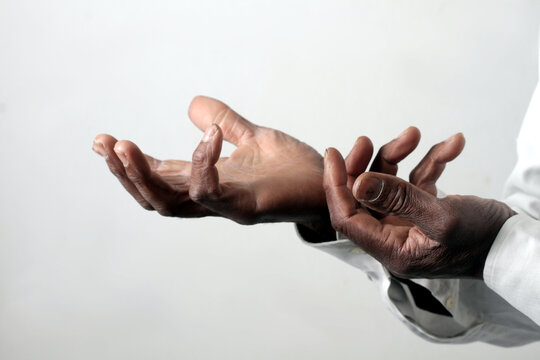 praying to god with hands showing his religious faith with God Caribbean man praying with background with people stock photo stock image	
