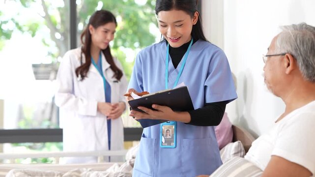Nurse writes on her clipboard in the foreground while the doctor continues speaking with the patient behind her. Ultra HD senior wellbeing footage from a contemporary care ward.