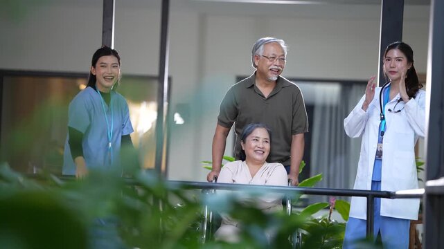 Group portrait in the corridor as the nurse laughs and covers her mouth beside the seniors and the doctor. 4K retirement and healthcare b-roll with warm natural lighting.