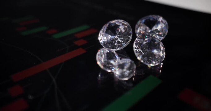 Diamonds reflecting on digital trading chart display with subtle dolly pan across glossy monitor surface probe lens.