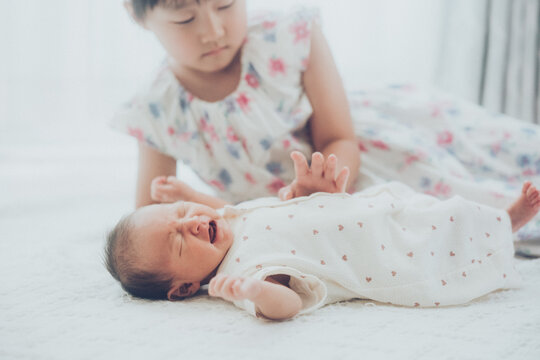 赤ちゃんをあやす小さなお姉ちゃん