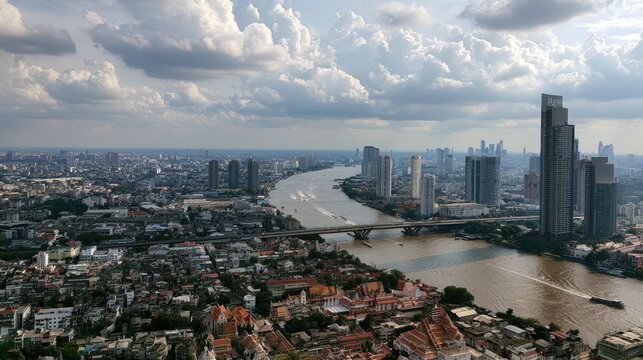 Bangkok Skyline Over Chao Phraya River: A panoramic view of the bustling Bangkok cityscape unfolds with the majestic Chao Phraya River carving its path through the urban sprawl.