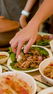Person Eating Thai Larb Moo Minced Pork Salad with Sticky Rice