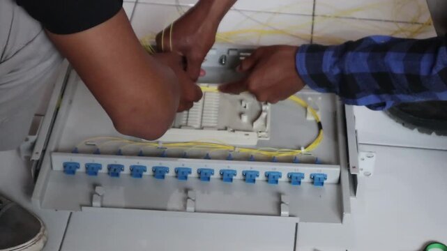 Technicians install fiber optic cables