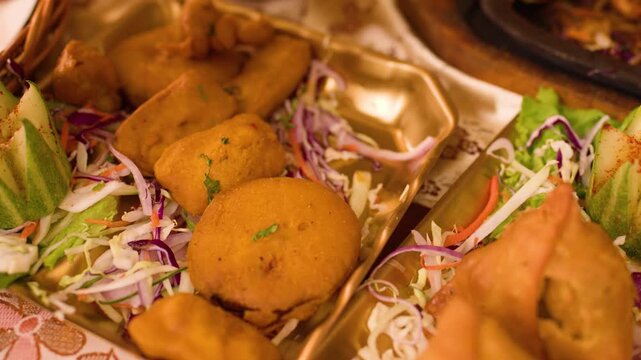 Serving Indian Appetizers with Tongs at a Restaurant Dinner