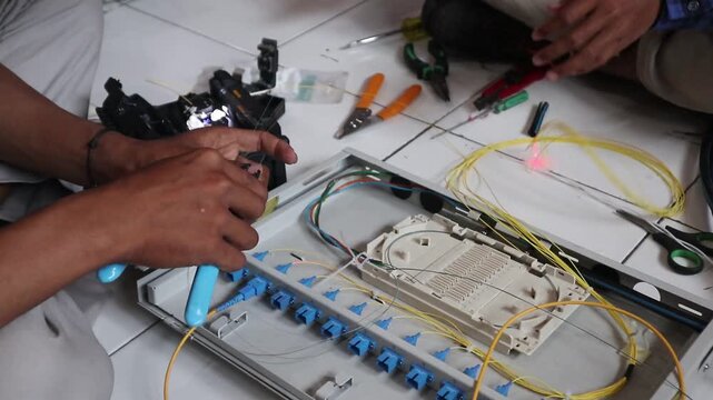 Technicians install fiber optic cables