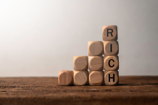 Wooden Blocks Forming Word Rich on a Wooden Table in Soft Light