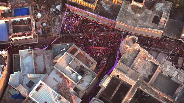 Cinematic Drone Shot of Lathmar Holi in Barsana Showing Traditional Lathi Playing Among Crowds in the Historic Village Streets of Braj, Uttar Pradesh