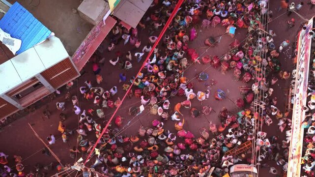 Cinematic Drone Shot of Lathmar Holi in Barsana Showing Traditional Lathi Playing Among Crowds in the Historic Village Streets of Braj, Uttar Pradesh