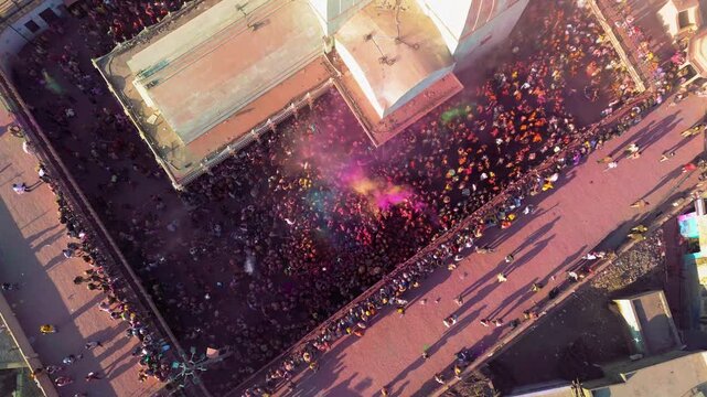 Top Down Drone View of Nand Baba Temple in Nandgaon During Holi with Colorful Gulal Clouds Filling the Air, Temple Courtyard and Vibrant Festival Celebration