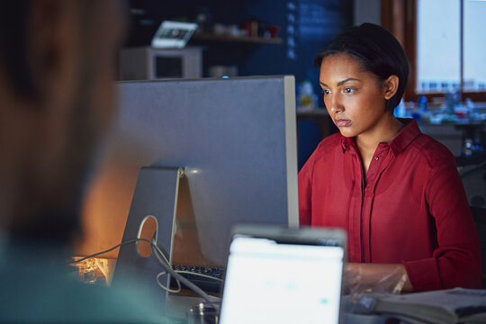 Woman, reading and report with computer for business research, website and article at night in office. Creative, editor and tech with coworking for online, startup and copywriting in workspace
