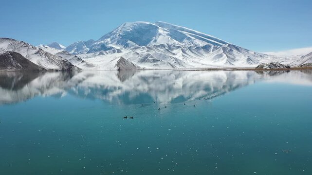Aerial view of Muztagh Ata snow mountain and Karakul Lake with reflection in Xinjiang, China