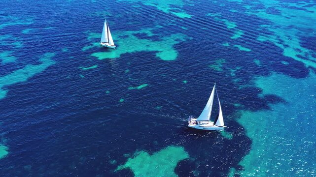 Aerial view of sailboat in the deep blue sea in Sardinia, Italy