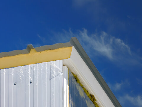 Construction of a modern warehouse with sandwich panels and insulation