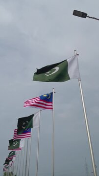 Pakistan Malaysia Diplomatic Relations Concept, Flags Waving Under Dramatic Clouds