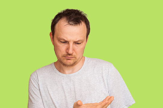 Man with thinning hair looking down with a thoughtful and concerned expression
