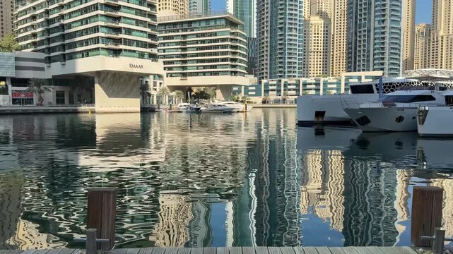 Captivating view of the Dubai Marina with yachts and towering buildings reflecting on the water.