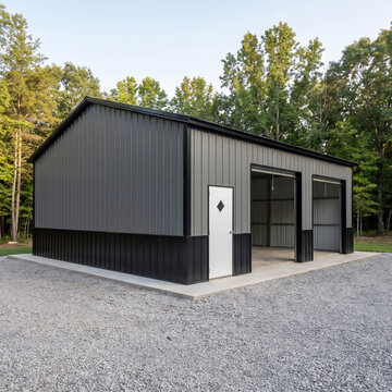 Modern charcoal steel frame building with entry doors in wooded background for storage applications