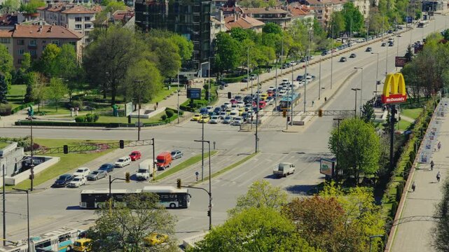 Elevated View of Busy City Traffic Intersection at NDK Park with Cars Buses and Greenery in Sofia