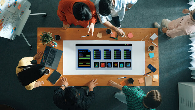 A diverse team of professionals collaborates over a digital interface in a vibrant modern office, surrounded by coffee cups, notes, and creative materials for brainstorming and planning. Ledger