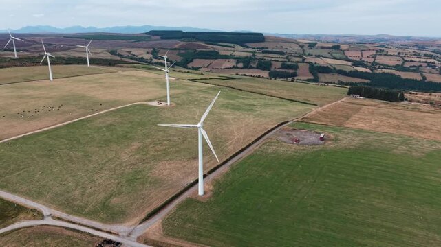 Imposing Clocaenog Dau Wind Farm turbine - fast anti-clockwise drone rotate from far, North Wales, UK