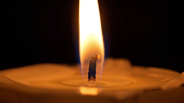 Close Up Candle Wick Burning with Soft Smoke and Warm Glowing Light