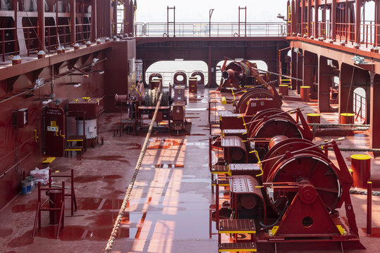 Aft mooring station on a modern container ship, featuring electric mooring winches, heavy-duty deck fittings and associated equipment used for securing and handling mooring lines during port operation