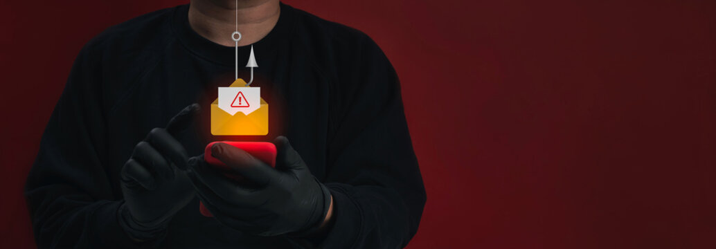 Anonymous cybercriminal scammer using smartphone to launch deceptive phishing email, with warning envelope and fishing hook symbolizing credential theft, online fraud and mobile security risk concept.