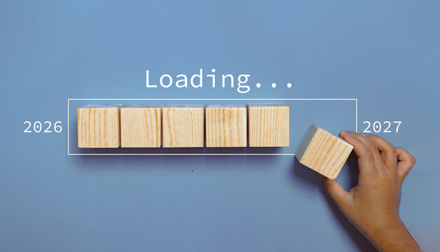 Hand assemble wooden block cube to update technology downloading tool bar status from 2026 to 2027 , Merry Christmas and happy new year concept.