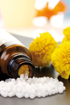 Medicinal flask with pills in front of Tagetes, close-up