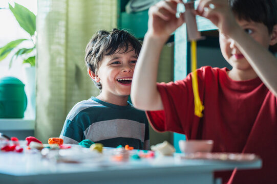 Happy boy plays with play dough at home