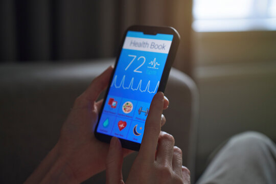Woman holds smartphone with health tracker app indoors