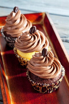 Tray of three with mocha beans decorated cup cakes in paper cups