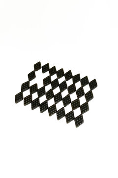 Black salty liquorice forms a geometric grid with a missing piece