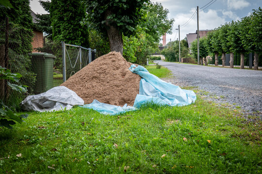Construction Sand Pile Stored Beside a Residential Gravel Road