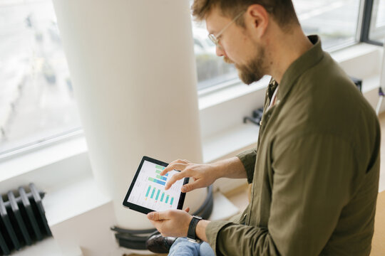Man analyzes financial data on a digital tablet in the office
