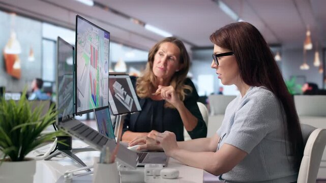 Two Urban Planners Discuss City Zoning Maps While Working