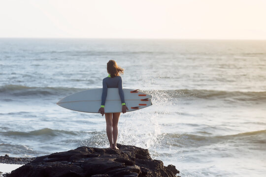 Indonesia, Bali, young woman with surfboard