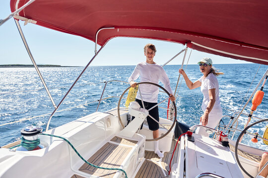 Mother and teenage son sail a boat on the Adriatic Sea in Croatia