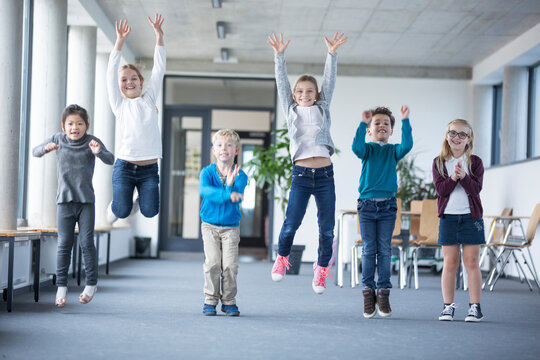 Enthusiastic students bouncing with joy down the school hallway
