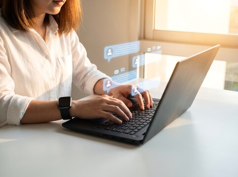 Woman typing on a laptop keyboard with social media and chat notification graphics floating nearby computer keyboard
