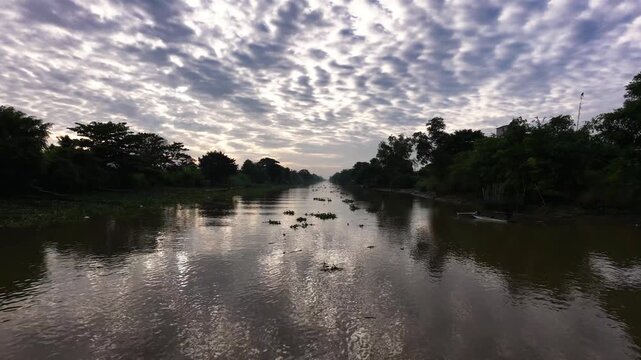 Low angle drone shot gliding smooth over river surface at sunrise