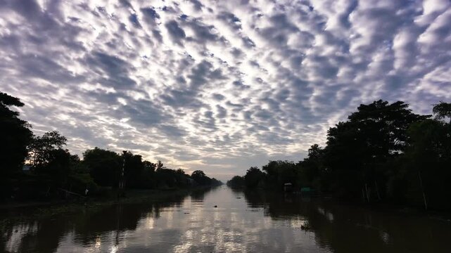 Low flying drone footage over calm waterway reflecting cloudy sky