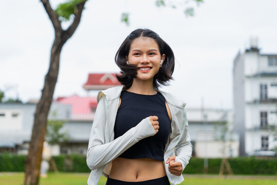 Asian sporty woman running in public park