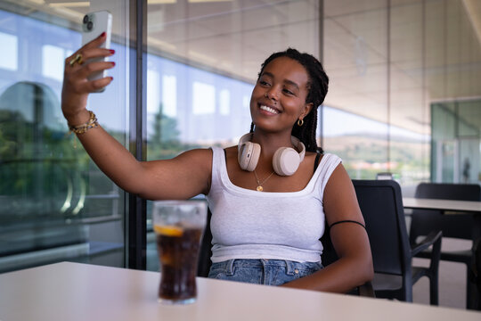 African American Woman wearing headphones takes a selfie on an outdoor