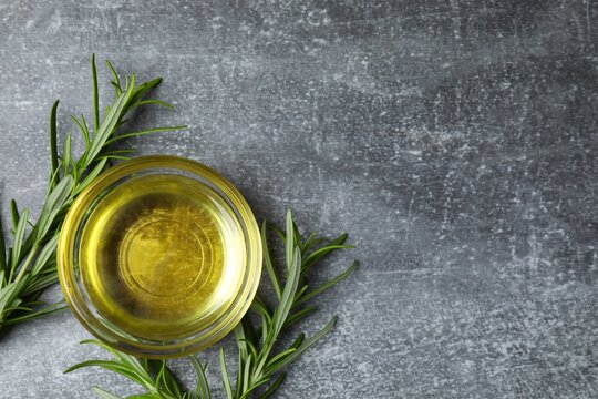 Rosemary oil in glass bowl with green rosemary sprigs, aromatic oil for cooking